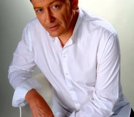 Jacek Borkowski na scenie podczas występu, ukazujący swoją wszechstronność jako aktor i wokalista.