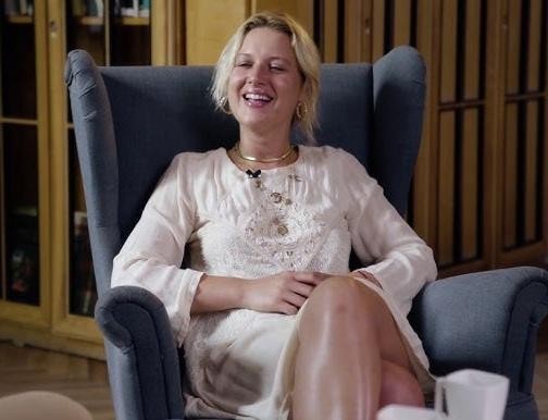 Aleksandra Domańska na planie filmowym lub za kulisami teatru, ukazana w chwili zaangażowania i pasji do aktorstwa, z widocznym duchem kreatywności.
