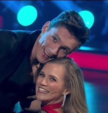 Agnieszka Kaczorowska w tanecznej pozie na scenie, w dynamicznym stroju.