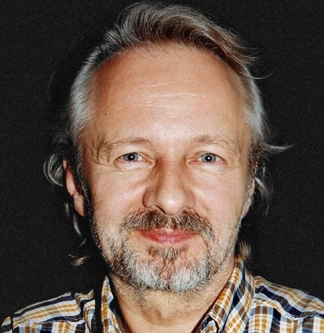 Krzysztof Stroiński w akcji na planie filmowym lub teatralnym, ukazujący jego zaangażowanie w pracę aktorską.