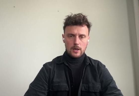 Wizualizacja kontrowersji wokół Łukasza Grabarczyka, z gazetowymi nagłówkami dotyczącymi zarzutów z Ukrainy i życia prywatnego, oraz sylwetkami sceptycznych postaci w tle.