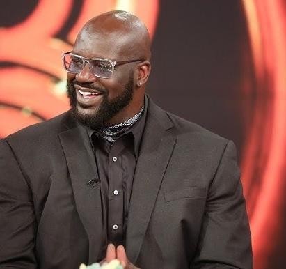 Shaquille O'Neal w koszulce Los Angeles Lakers, w akcji na boisku, ukazujący jego dominującą sylwetkę i skupienie podczas gry.
