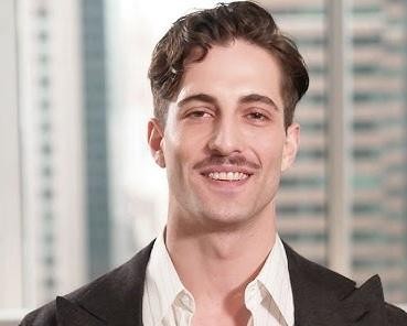 Damiano David z Måneskin w trakcie intensywnego występu na scenie, trzymający mikrofon, z dynamicznym oświetleniem i wyrazem skupienia.
