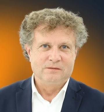 Jacek Karnowski podczas spotkania, uśmiechnięty, w nieformalnym otoczeniu, z Sopotem w tle, ukazujący jego bliskość z mieszkańcami i miastem.