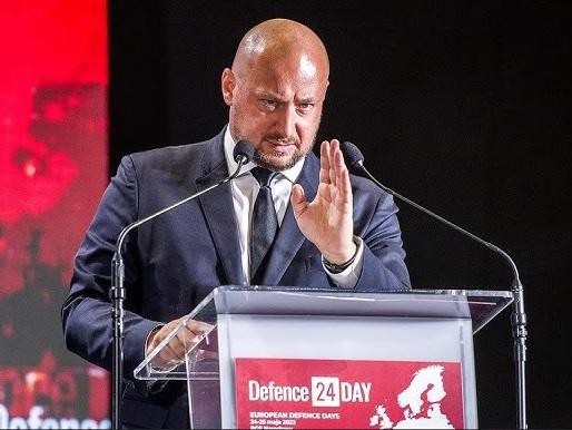 Jacek Siewiera w dynamicznej pozie, symbolizującej jego rolę jako lidera i eksperta w dziedzinie bezpieczeństwa narodowego, z subtelnymi nawiązaniami do jego medycznej i prawnej przeszłości.